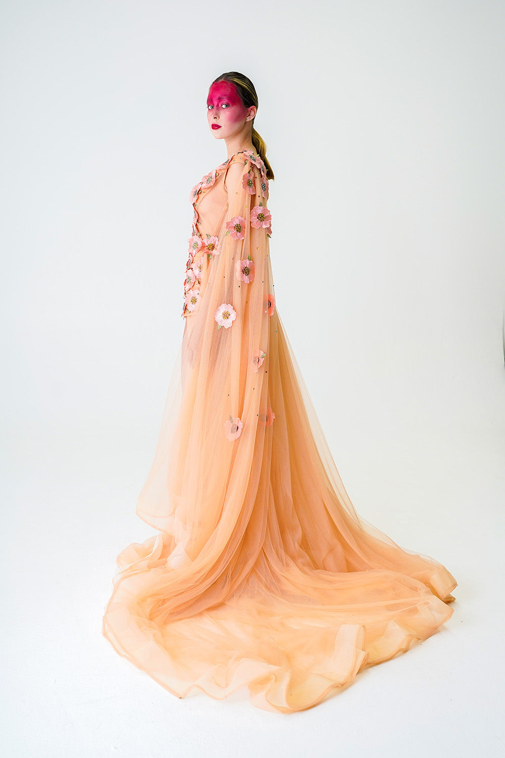 NUDE MINI DRESS WITH ONE SHOULDER CAPE AND CASCADING FLORAL APPLIQUE DETAILS